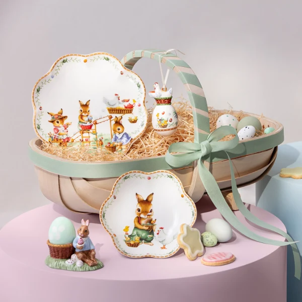 Annual Easter Edition 2026 tableware set on table Annual Easter Edition 2026 tableware with bunny designs, eggs, a mug, and cookies arranged on pastel-colored platforms.