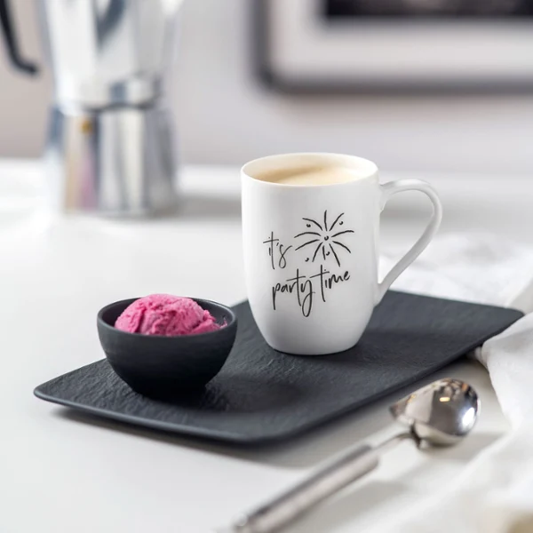 A Statement cup with the words "It's Party Time" on a tray A Statement cup with the words "It's Party Time" on a tray next to a small black bowl of ice cream.