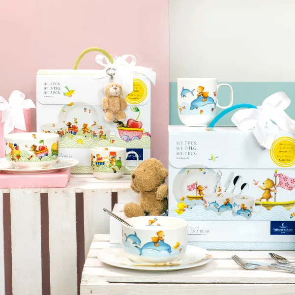 Happy as a bear et Hungry as a bear sur une table comme cadeaux Des articles cadeaux et un ensemble de vaisselle pour enfants Happy as a bear et Hungry as a bear sur une table avec un fond pastel.