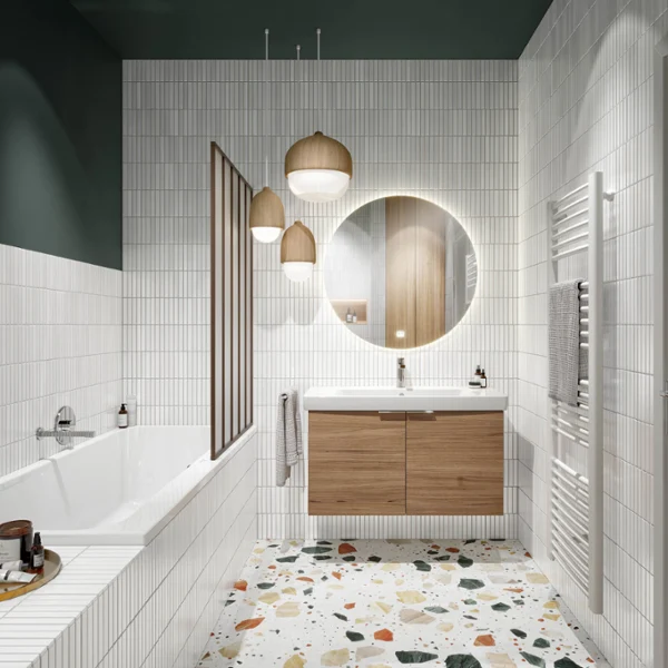 Un cuarto de baño Architectura con azulejos blancos, un lavabo de madera con espejo redondo iluminado, lámparas colgantes y un radiador blanco a la derecha. A la izquierda hay una bañera blanca con grifería gris.