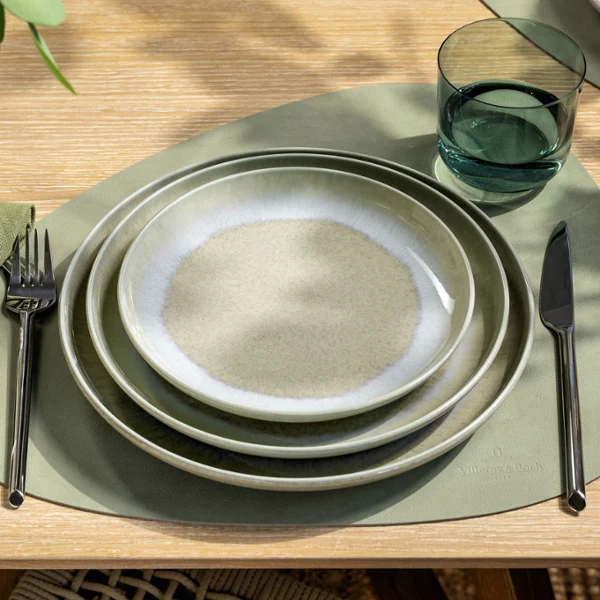 Perlemor Alga & Like Sage – Nature-Inspired Dining in Green Hues Top-down view of a table setting with Villeroy & Boch’s Perlemor Alga plates in layered shades of soft green, combined with a Like Sage water glass. The setting reflects a naturally calm, earthy aesthetic with handcrafted character and subtle tonal variations.