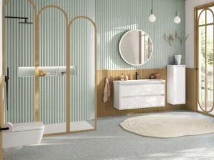 Large, pastel green family bathroom with shower area, vanity unit with white base cabinet, round illuminated mirror, side cabinet, black faucets and rectangular, wall-hung toilet from the Skyla collection.