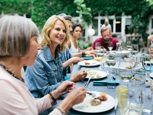 A set table where several people are eating and talking in the garden
