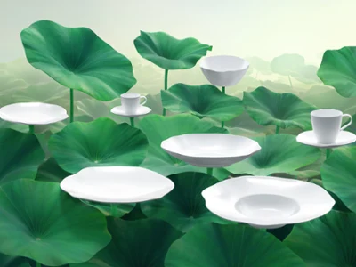 Elegant white dinnerware with flowing, organic shapes. Plates and Cups are flowing. Weißes Pura Geschirr auf Tisch mit Etagere, zwei grünen Vasen und grünen Akzenten