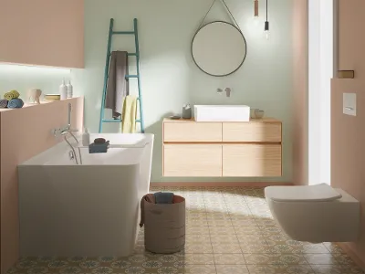 Collaro WC und Waschtisch in Weiß, kombiniert mit einem Waschtischunterschrank in Oak in modernem Badezimmerdesign. Modernes Badezimmer mit Collaro WC, weißem Waschtisch und einem Waschbeckenschrank in Oak mit rundem Spiegel. Der Boden besteht aus gemusterten Fliesen und die Decke ist mit Holzpaneelen designt.