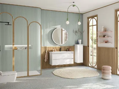 Large, pastel green family bathroom with shower area, vanity unit with white base cabinet, round illuminated mirror, side cabinet, black faucets and rectangular, wall-hung toilet from the Skyla collection.