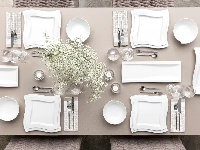 Das Tischset NewWave von Villeroy & Boch umfasst quadratische weiße Teller, Schüsseln, Besteck, Gläser und einen Tafelaufsatz mit weißen Blumen auf einer beigen Tischdecke für vier Personen.