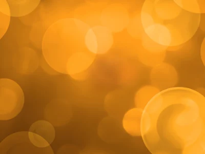 Summer Sale Bild auf abstraktem Hintergrund Abstrakter Hintergrund mit großen und kleinen goldgelben Bokeh-Kreisen vor einem unscharfen, warmtonigen Hintergrund.