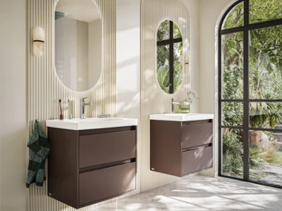Skyla vanity units with mirror in a modern bathroom Modern bathroom with two wall-mounted washbasins, oval mirrors, fluted wall panels and a large window overlooking lush greenery.