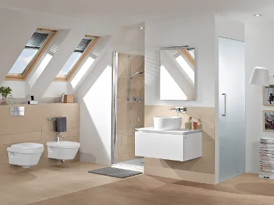 Architectura Badezimmer mit weißem WC und Bidet und passendem Waschbecken mit Spiegel Modernes Bad mit wandhängendem WC und Bidet von Architectura, schwebendem Waschtisch mit Waschbecken und Spiegel, verglaster Dusche, Dachfenster und einer Lampe.