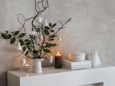 Modern Christmas decoration on a white shelf Modern, minimalist Christmas decoration on a white shelf with a Winter Glow vase, twigs and hanging ornaments.