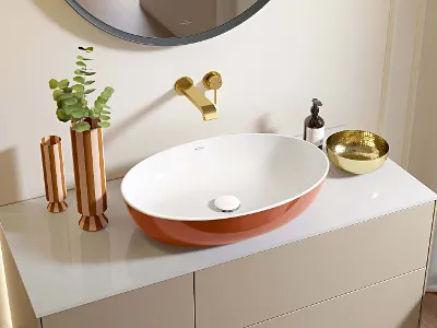 Artis Waschbecken in Rust in modernem Bad Ein modernes, orange-weißes Waschbecken im Badezimmer mit goldenen Armaturen und dekorativen Accessoires