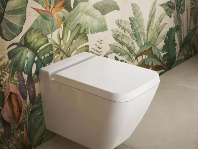 Finion WC weiß mit Sitz vor Pflanzentapete Ein wandhängendes Finion WC mit Sitz und Deckel ist an einer Vorwand mit Pflanzenmuster angebracht.