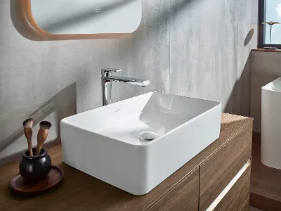 Collaro Waschtisch und Unterschränke in modernem Badezimmer mit Meerblick Modernes Badezimmer-Interieur mit einem Waschtisch und Holzschränken aus der Kollektion Collaro vor dem Hintergrund eines Fensters mit Meerblick.