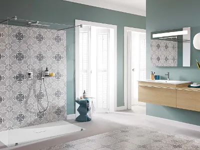 Badezimmer mit Venticello Glasdusche und Holzwaschtisch Modernes Badezimmer mit Glasdusche, kunstvoll gemusterten Wandfliesen, schwebendem Holzwaschtisch, großem Spiegel und weißen Hängelampen. Der Raum hat sanfte grüne Wände und natürliches Licht durch zwei Fenster.