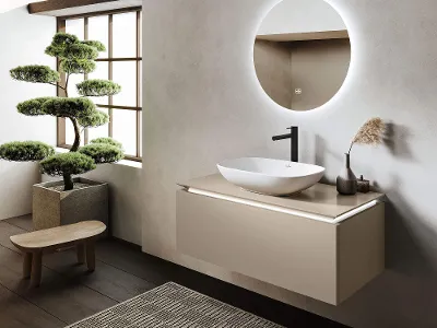 Weißes Loop & Friends Waschbecken mit Legato Unterschrank Modernes Badezimmer mit einem weißen Loop & Friends Aufsatzwaschbecken auf einem beigen Legato Unterschrank, einem runden Spiegel, großen Fenstern und einem Bonsai-Baum auf einem Holzhocker