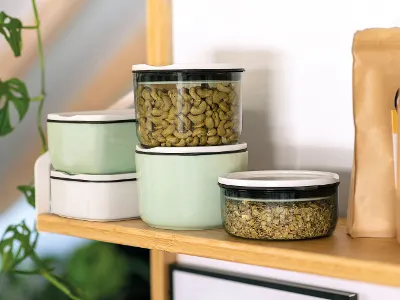 I contenitori ToGo di Villeroy & Boch sono impilati accanto a un sacchetto di carta marrone su uno scaffale di legno.