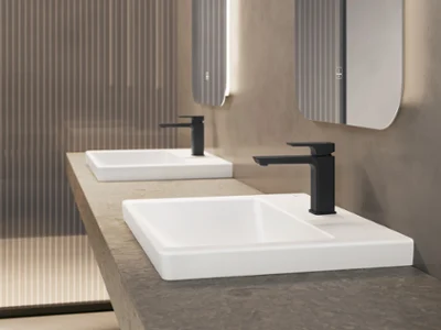 Perfect in combination with black Villeroy & Boch taps A modern bathroom has a concrete work surface with two white rectangular washbasins and black taps below two mirrors