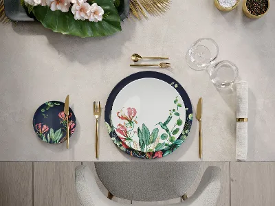 Gedeckter Platz mit Avarua Teller und goldenem MetroChick Besteck Ein Tischgedeck mit Blumenmuster-Geschirr von Avarua und goldenem MetroChic Besteck.