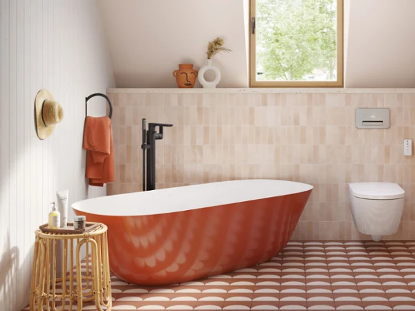 Rust-red Villeroy & Boch Theano bath A modern bathroom with a red freestanding bath, a wooden washstand with a black washbasin, a wall-mounted toilet