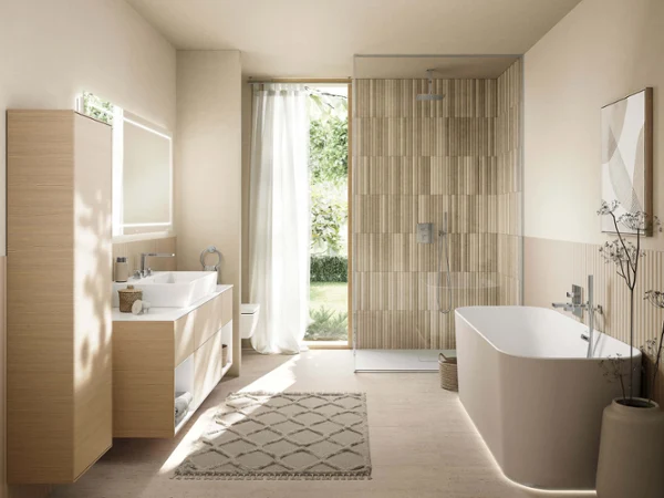 White Finion bathtub with LED lighting Modern bathroom with freestanding bathtub, double washbasins, glass shower and natural light from a large window.