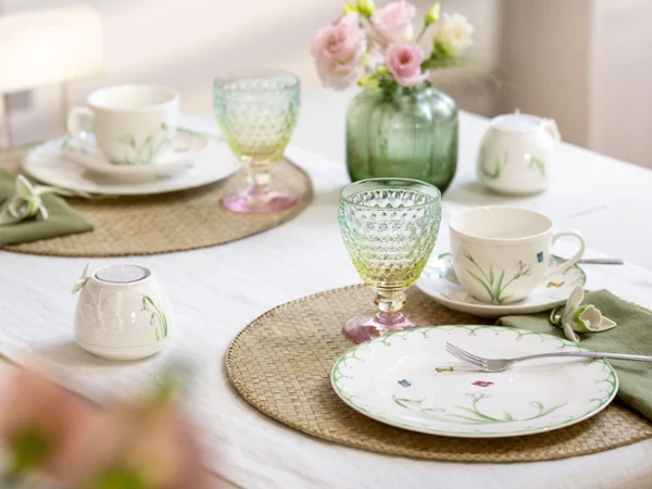 The Colourful Spring set from Villeroy & Boch embellishes any table for two with plates and cups with a floral pattern The Colourful Spring set from Villeroy & Boch embellishes any table for two with plates and cups with a floral pattern, bright green and yellow glasses, pink flowers in a vase and beige placemats on a white tablecloth.