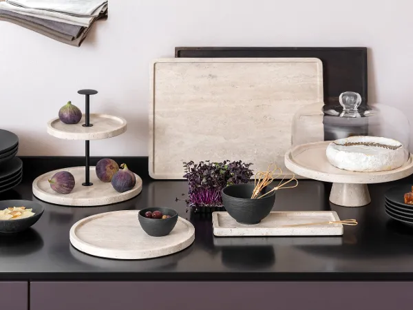 Manufacture Travertin and Manufacture skilfully staged Kitchen countertop with elegant Manufacture Travertine trays, on which figs, brie, bread and a bowl of vegetables are presented.