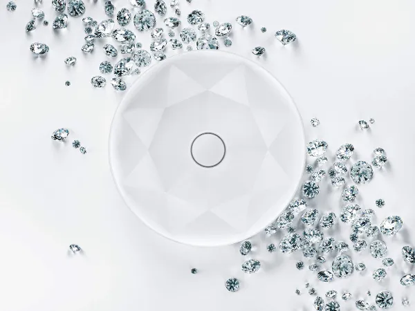 Octagon Waschbecken mit Diamanten von Villeroy & Boch Ein rundes, weißes Waschbecken mit geometrischem Muster ist von verstreuten kleinen und großen, klaren, facettierten Edelsteinen auf einem weißen Hintergrund umgeben.