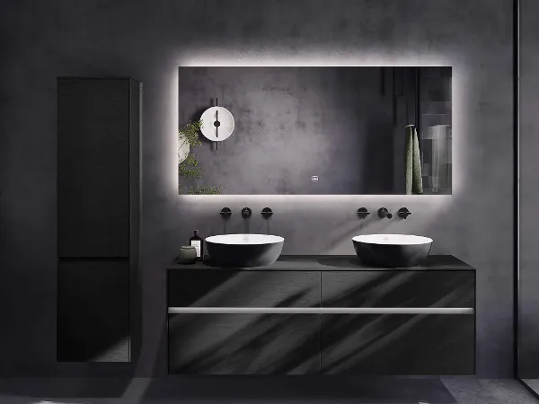 Schwarzes Badezimmer mit zweifarbigen Aufsatzwaschbecken Modernes Badezimmer mit Doppelwaschbecken, großem hinterleuchtetem Spiegel, schwarzen Schränken und minimalistischen Armaturen vor grauen Wänden.