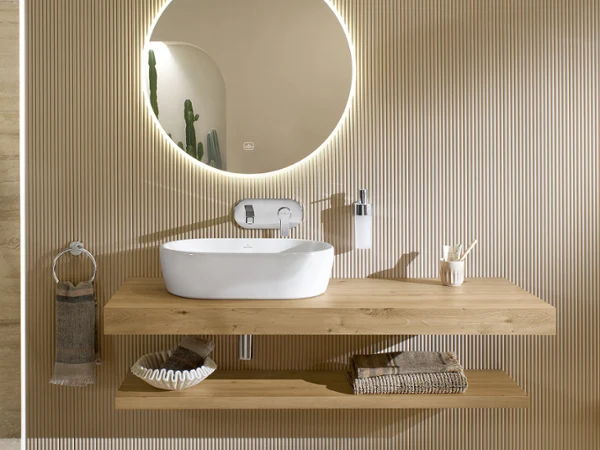 Modern Bathroom with Architectura Washbasin and More to See Lite+ Mirror A contemporary bathroom interior featuring a Villeroy & Boch Architectura countertop washbasin on a floating wooden vanity, paired with a round More to See Lite+ mirror with integrated LED lighting.