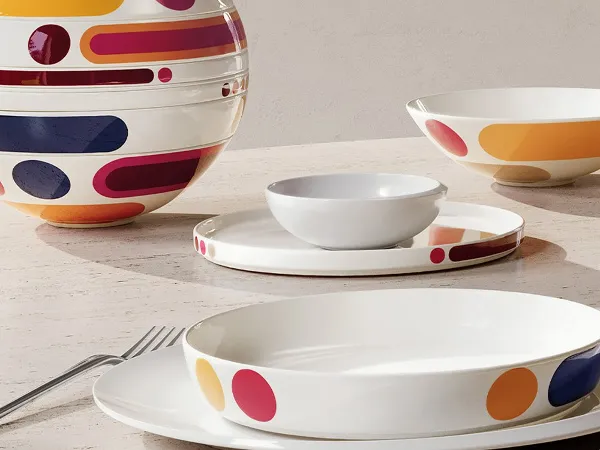 Tavolo ovale in pietra con La Boule Miami moderna e colorata. Una volta insieme, una volta come pezzi singoli, disposti su una grande finestra con una sedia.