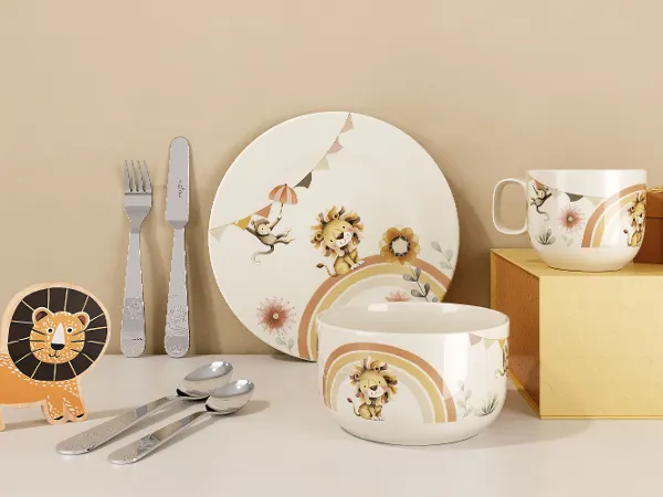 Boho Kids | Roar like a Lion Zestaw Naczyń od Villeroy & Boch Zestaw naczyń 'Boho Kids | Roar like a Lion' od Villeroy & Boch zawiera talerz, miskę, kubek, sztućce oraz figurkę z motywem lwa, zaprezentowany na białej powierzchni z beżowym tłem.