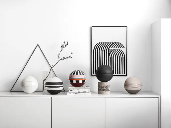 Five La Boule dinnerware sets on a white shelf A white shelf with several La Boule dinnerware sets on top.