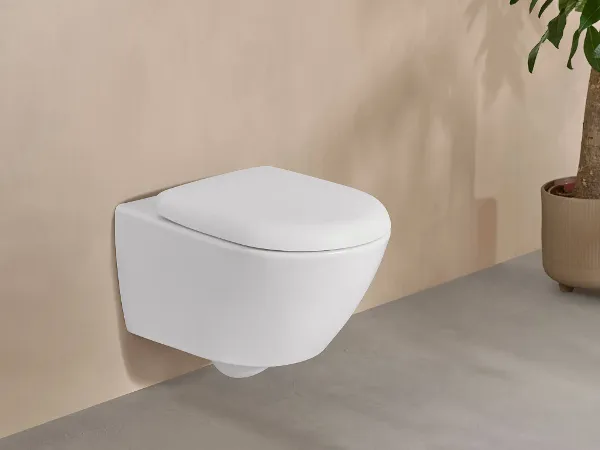 Weiße Antao Toilette in beigem Badezimmer Eine weiße Antao Toilette von Villeroy & Boch in einem eleganten beigen Bad mit Topfpflanze.