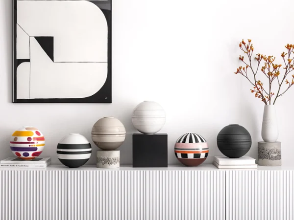 Vijf La Boule serviessets op een witte plank Een witte plank met verschillende La Boule servies-sets erop.