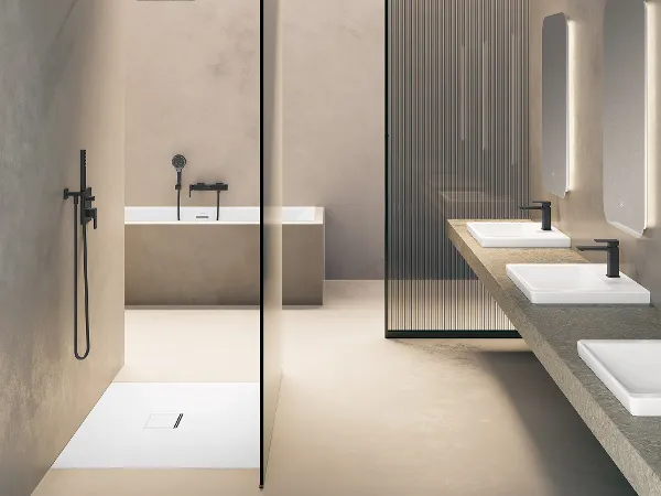 Subway 3.0 Badkeramik von Villeroy & Boch mit Armaturen Modernes, minimalistisches Badezimmer mit beigen Wänden, einer großen Badewanne, einer ebenerdigen Dusche mit schwarzen Armaturen und einem Doppelwaschtisch unter rechteckigen Spiegeln. Eine undurchsichtige Glasscheibe trennt den Badewannenbereich.