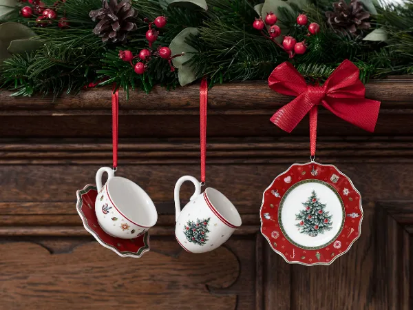 Toy’s Delight ornaments, hanging on red ribbons from a wooden mantelpiece decorated with mistletoe and berries.
