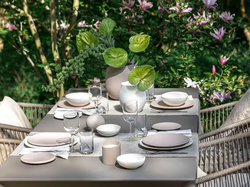 Gedeckter Tisch mit NewMoon Kollektion Ein Esstisch mit NewMoon Geschirr von Villeroy & Boch in einem Garten.