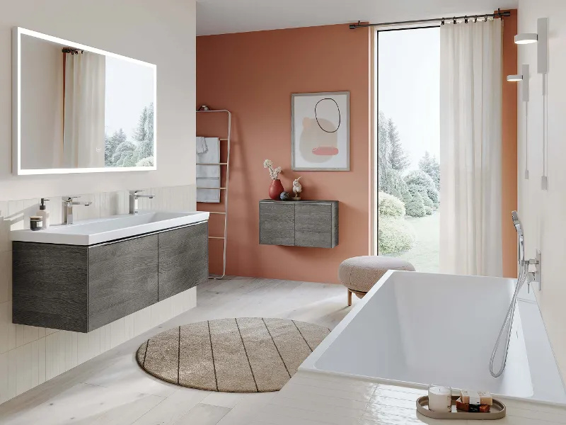 A modern bathroom with orange-coloured walls and a white Subway 3.0 bath.