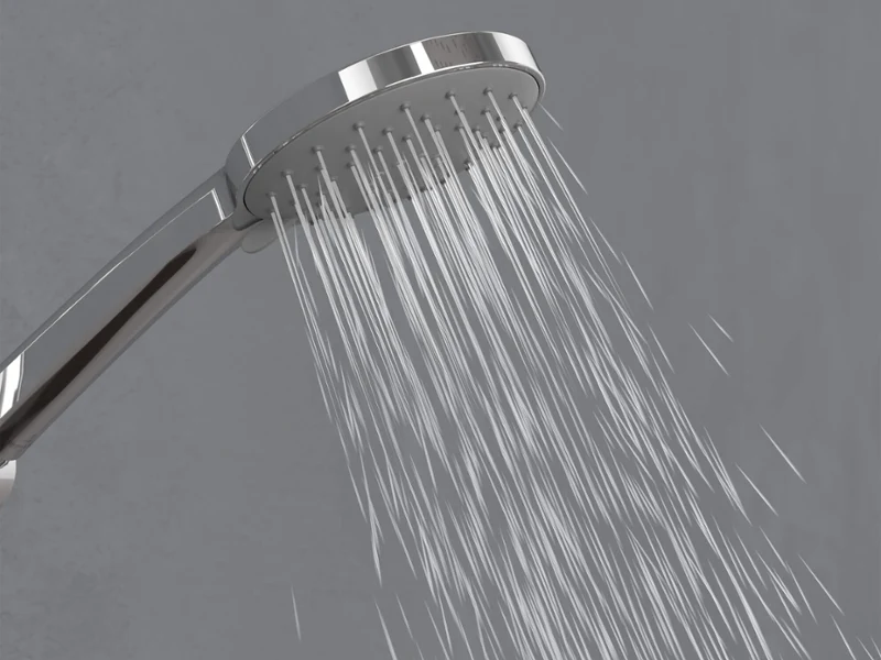 Universal Showers hand shower in Massage mode A chrome shower head spraying gentle streams of water downward against a simple grey background.