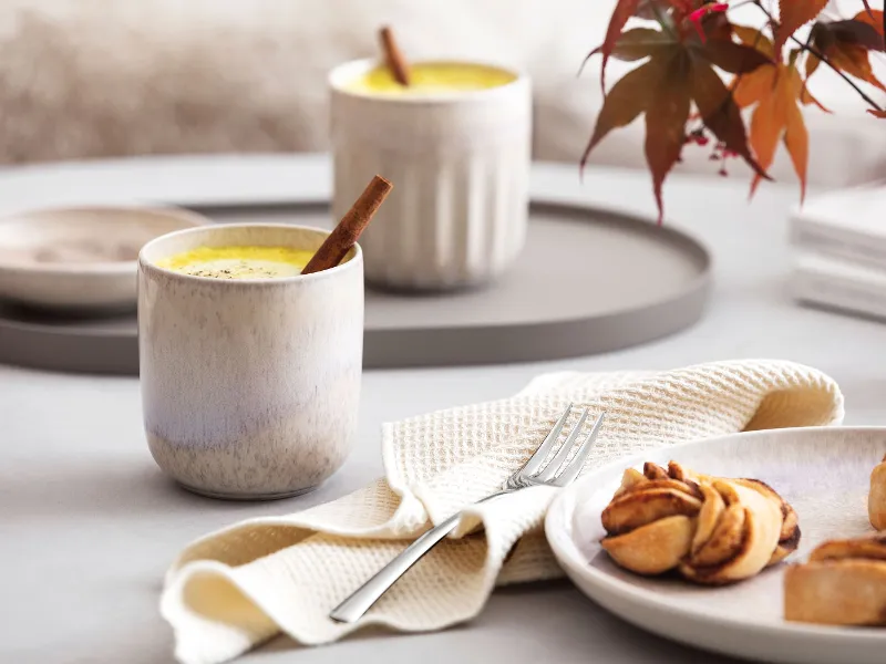 A plate with biscuits and a cup of coffee in a like. by Villeroy & Boch Perlemor mug on a table.