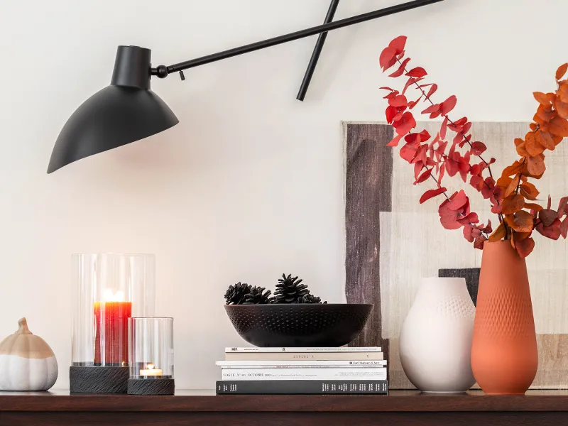 Modern sideboard with Manufacture decorative items and an adjustable wall light.