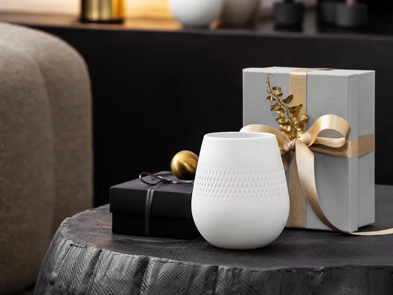 A small Manufacture Collier Blanc Carré vase and with subtle texture and wrapped gifts, ideal for single blooms or minimal arrangements.