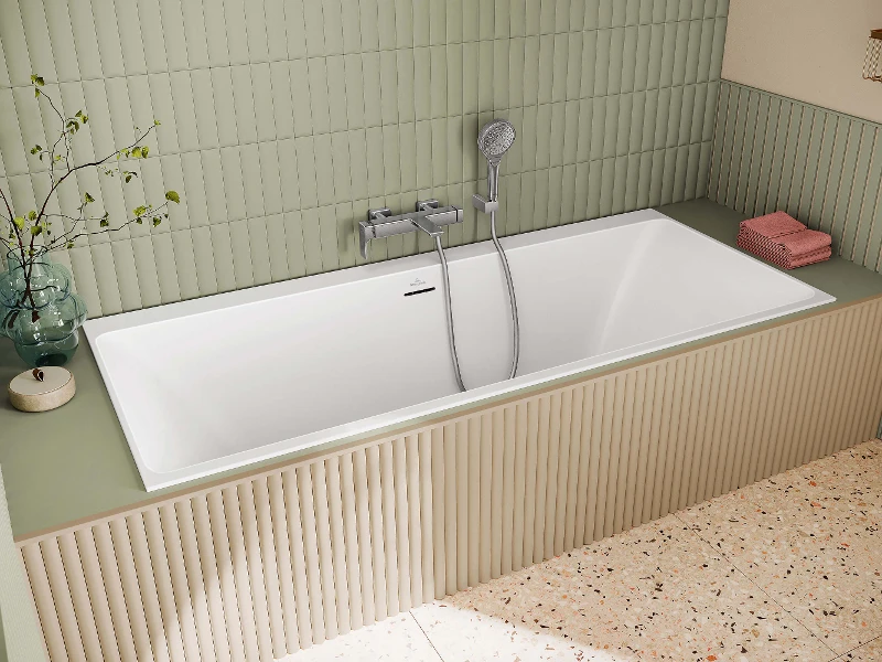 Subway 3.0-badekararmatur med hånddusj Et Subway 3.0-badekararmatur på et badekar med hånddusj foran en grønn, flislagt vegg