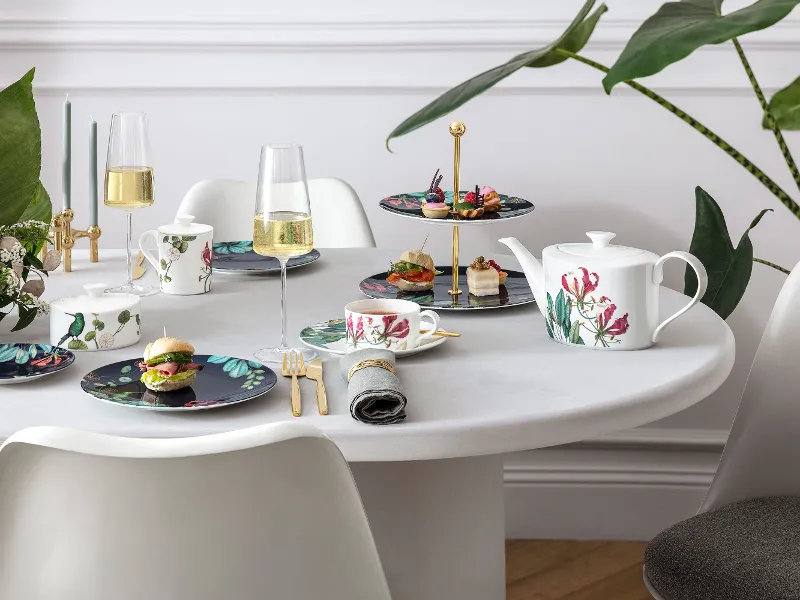 Eleganter Esstisch mit Avarua Geschirr und MetroChic Sektgläsern, dazu eineTeekanne und moderne Stühle.