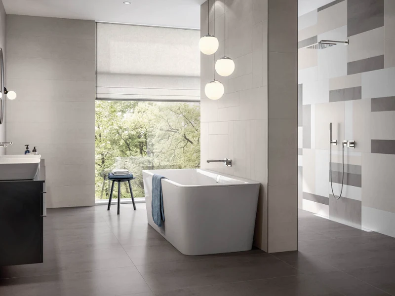 Biała wanna Squaro Biała wanna Squaro w nowoczesnej łazience z czarną podłogą i beżowymi płytkami.