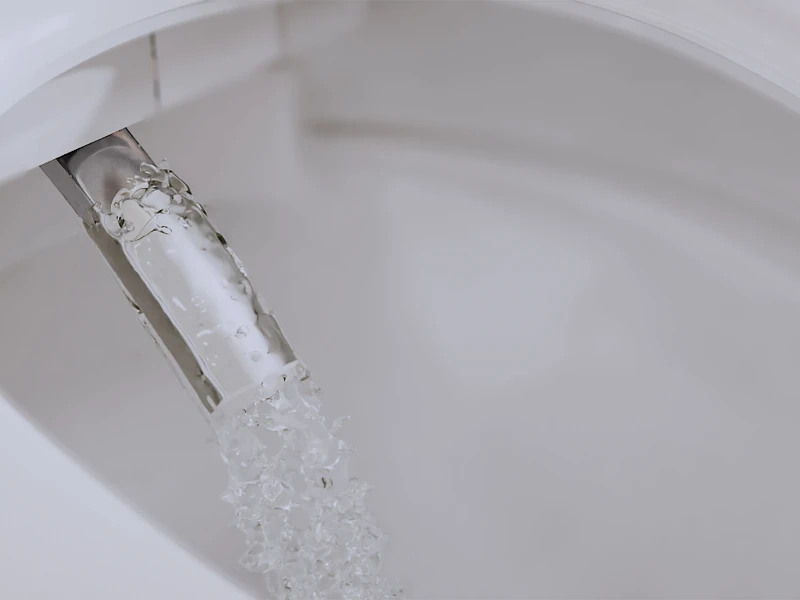 Nærbilde av Tivo dusjtoalettmunnstykke som skylles med vann Tivo dusjtoalett med spyling av munnstykke sikrer maksimal hygiene med automatisk rengjøring før og etter bruk.