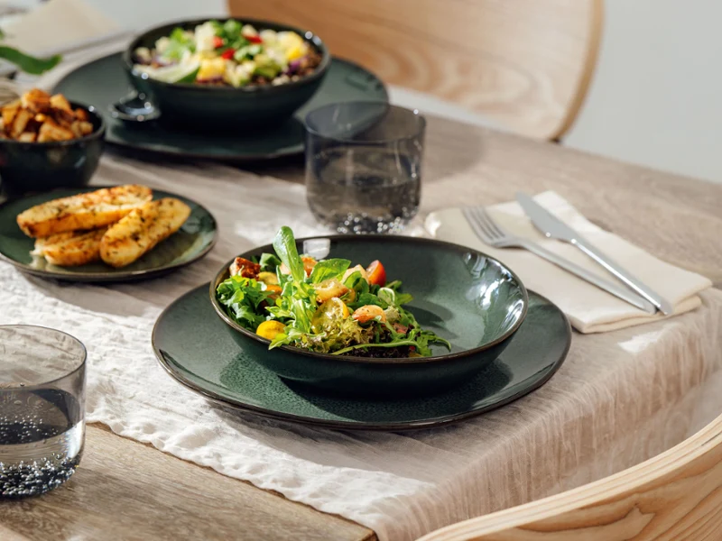 Lave Vert table setting with dinner plate, bowl, and fresh salad A stylishly set table with Lave Vert tableware – a green dinner plate, a matching bowl, and fresh salad – the perfect combination of handcrafted design.