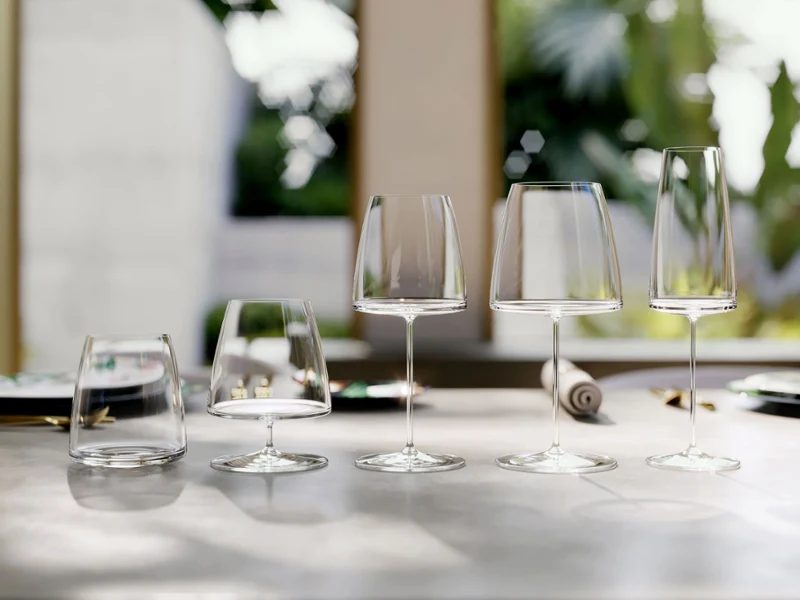 MetroChic glasses on a polished table, elegantly arranged, with a blurred garden backdrop.