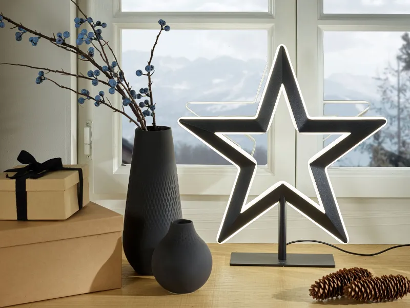 A festive arrangement of Manufacture Noir Collier and Perle vases decorated for a modern Christmas table.